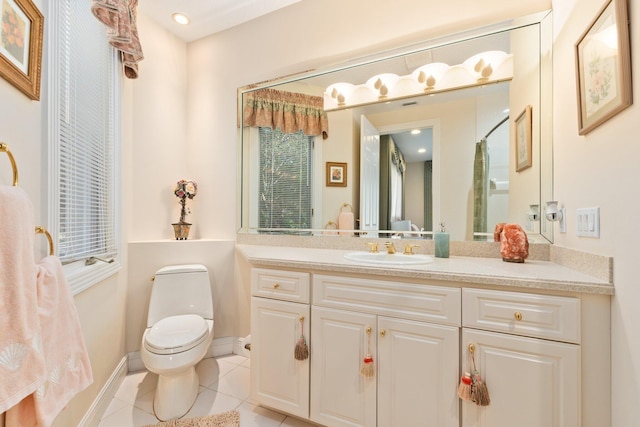 bathroom with toilet, vanity, and tile patterned floors