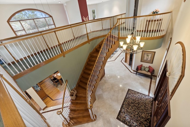 staircase featuring a towering ceiling and a chandelier