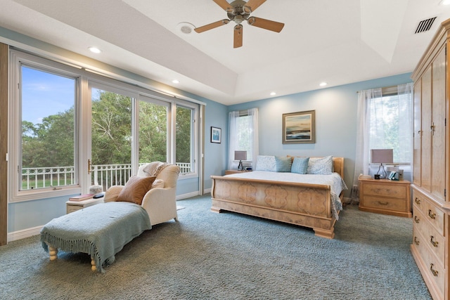 bedroom with a tray ceiling, access to exterior, ceiling fan, and dark carpet