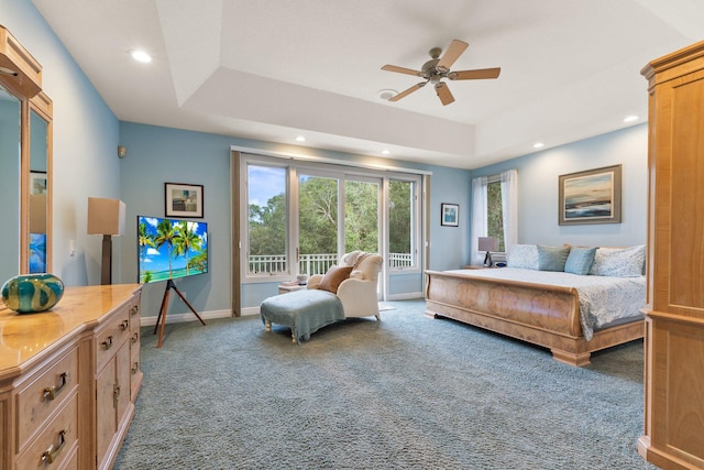 bedroom featuring a tray ceiling, ceiling fan, and carpet flooring