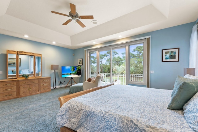 bedroom with a raised ceiling, ceiling fan, carpet flooring, and access to outside