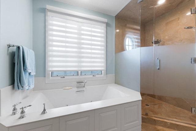 bathroom featuring a wealth of natural light and independent shower and bath