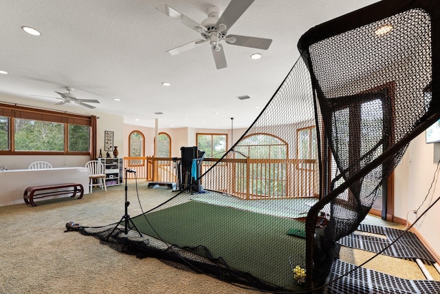 workout room with carpet flooring, a textured ceiling, and ceiling fan