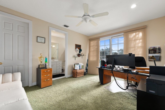 carpeted home office featuring ceiling fan