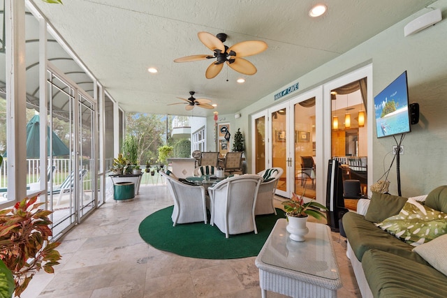 sunroom / solarium featuring ceiling fan and french doors