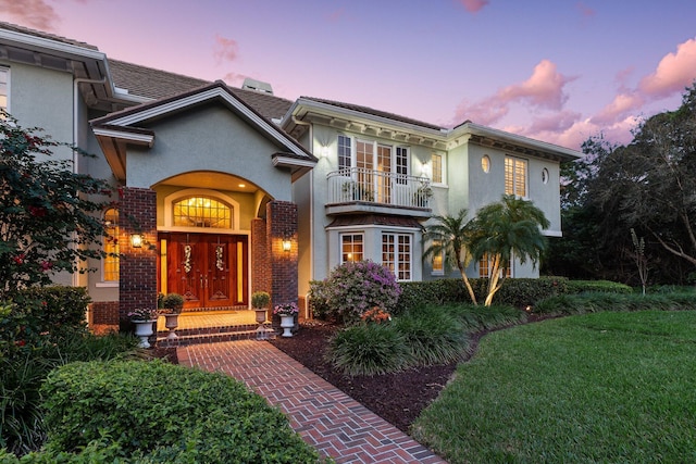 view of front facade with french doors and a balcony