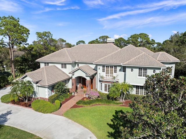 view of front of home featuring a balcony and a front yard