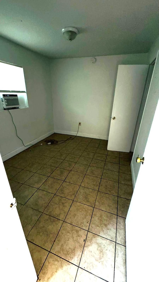 spare room featuring tile patterned flooring and cooling unit