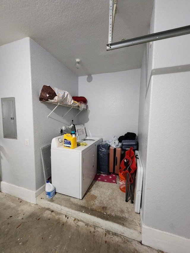 laundry room with washer and dryer, a textured ceiling, and electric panel