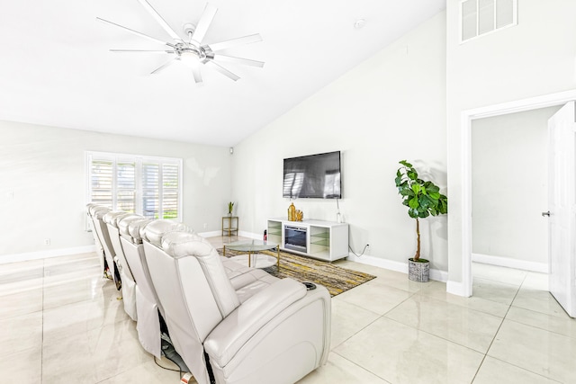 tiled living room with ceiling fan and vaulted ceiling