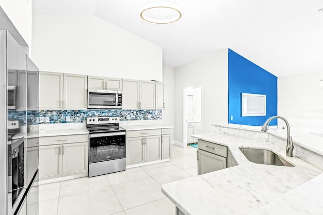 kitchen with light tile patterned floors, tasteful backsplash, gray cabinets, appliances with stainless steel finishes, and sink