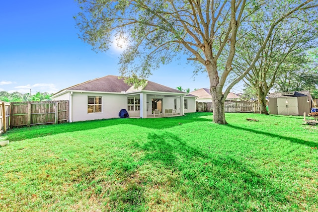 back of house with a yard and a storage unit