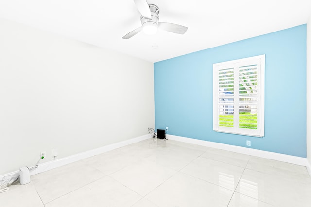 tiled spare room featuring ceiling fan