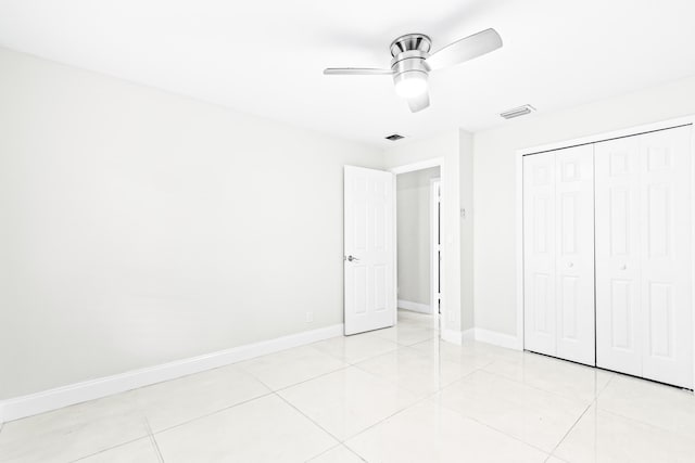 unfurnished bedroom featuring ceiling fan, light tile patterned floors, and a closet