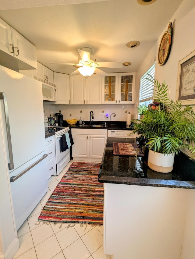 kitchen featuring light tile patterned flooring, tasteful backsplash, white cabinetry, sink, and white appliances