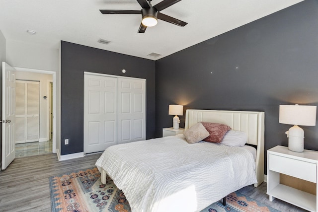 bedroom featuring ceiling fan, a closet, and hardwood / wood-style flooring