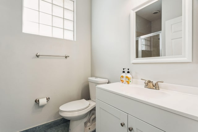 bathroom featuring tile patterned flooring, vanity, toilet, and a shower with shower door