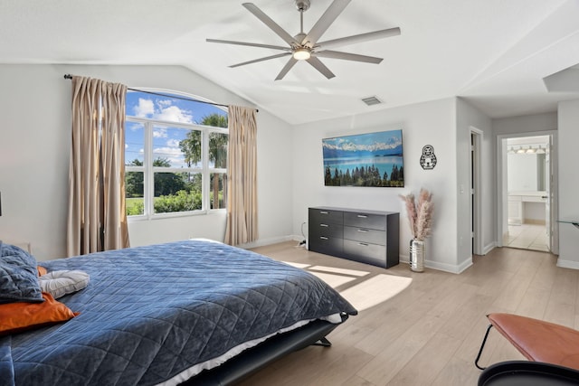 bedroom with light wood-type flooring, connected bathroom, ceiling fan, and lofted ceiling