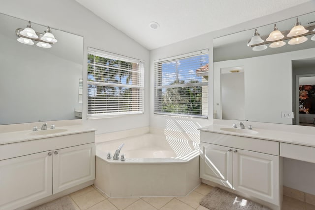 bathroom with vanity, tile patterned floors, lofted ceiling, and a tub