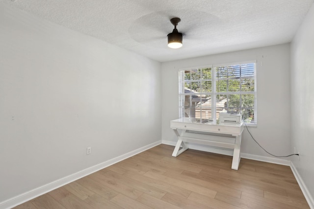 unfurnished room with ceiling fan, light hardwood / wood-style flooring, and a textured ceiling