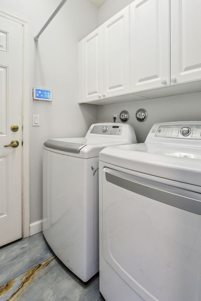 washroom featuring cabinets and washing machine and clothes dryer