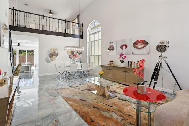 dining area featuring ceiling fan and a towering ceiling