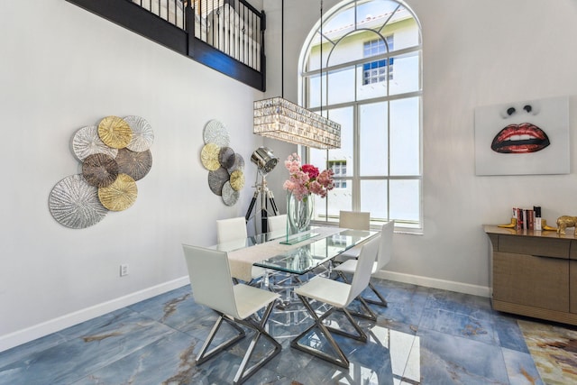 dining space with a towering ceiling