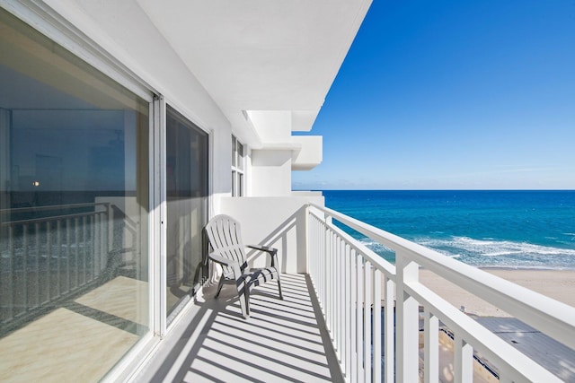 balcony with a water view and a beach view