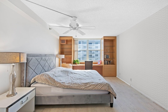 bedroom with ceiling fan, light hardwood / wood-style flooring, and a textured ceiling