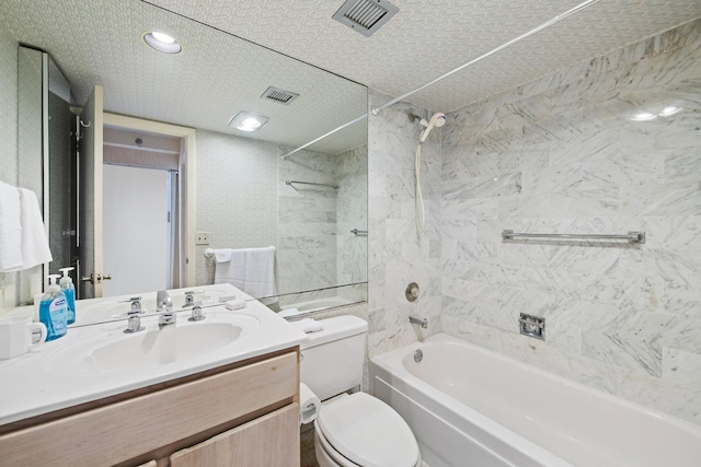 full bathroom with vanity, a textured ceiling, tiled shower / bath combo, and toilet