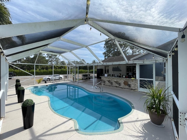 view of swimming pool with a patio area and glass enclosure