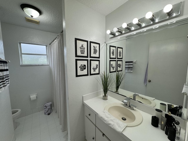 bathroom featuring vanity, a textured ceiling, and toilet