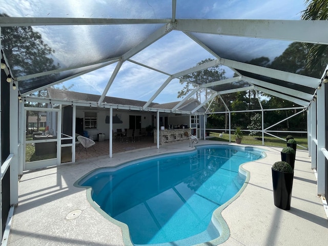 view of swimming pool featuring a lanai and a patio area