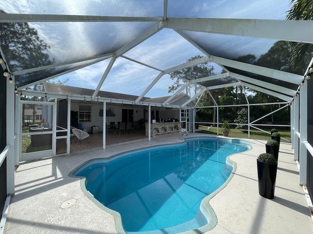 view of swimming pool featuring a lanai and a patio area