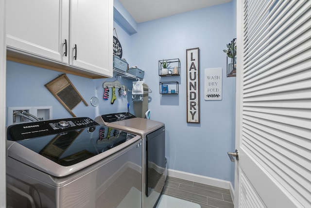 clothes washing area featuring cabinets and washing machine and clothes dryer