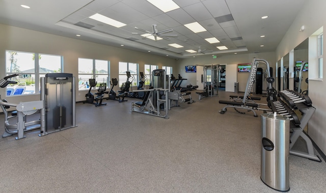 gym with a paneled ceiling and ceiling fan