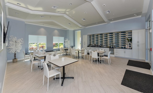 dining room with light hardwood / wood-style flooring and high vaulted ceiling