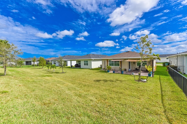 back of property with a yard and a patio