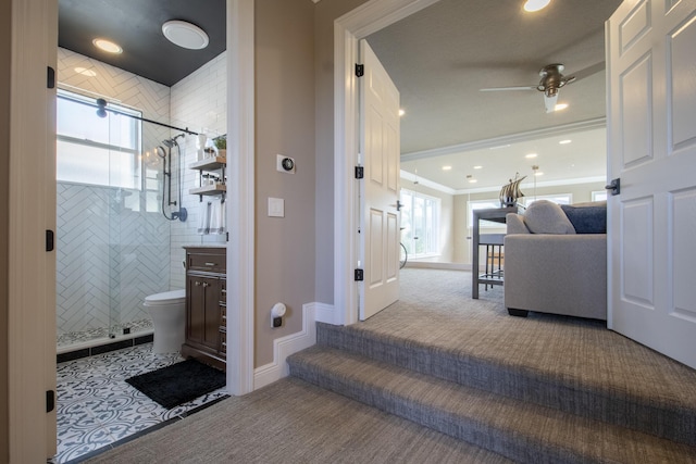 bathroom featuring toilet, a shower with door, ceiling fan, ornamental molding, and vanity