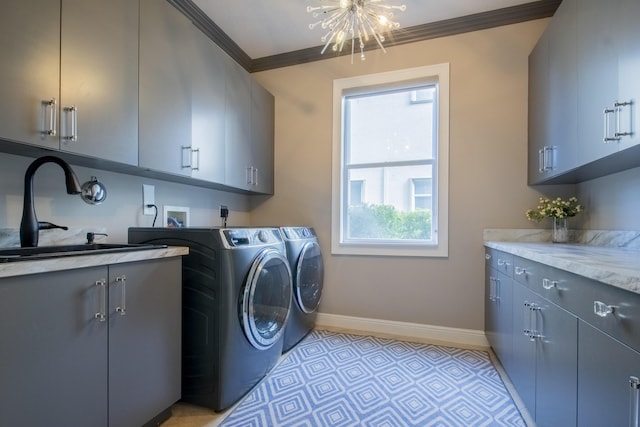 laundry room featuring an inviting chandelier, cabinets, crown molding, washer and dryer, and sink