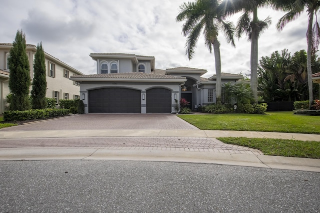 mediterranean / spanish house featuring a front lawn and a garage