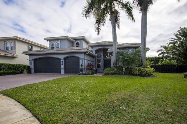 mediterranean / spanish-style home with a front lawn and a garage