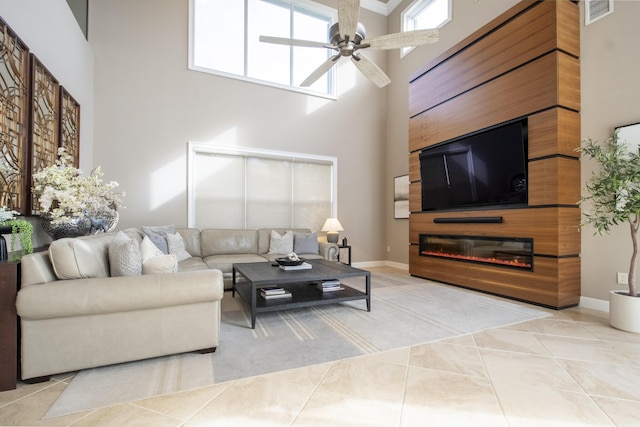 tiled living room with a high ceiling and ceiling fan