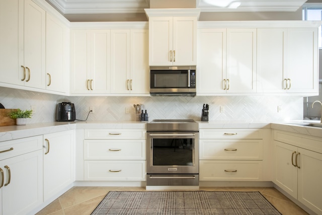 kitchen featuring stainless steel appliances, light tile patterned floors, white cabinets, and tasteful backsplash