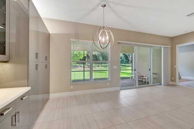 unfurnished dining area with a notable chandelier and light tile patterned flooring