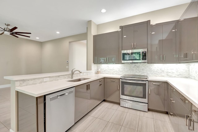 kitchen featuring sink, gray cabinets, light tile patterned floors, kitchen peninsula, and stainless steel appliances