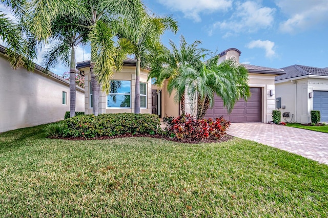 view of front of home with a front yard and a garage