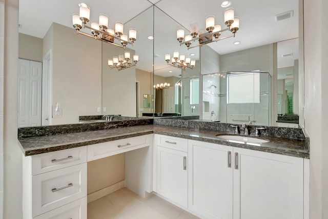 bathroom featuring a shower with door, vanity, and tile patterned flooring