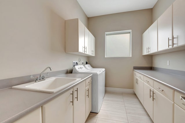 clothes washing area featuring cabinets, light tile patterned floors, washer and clothes dryer, and sink