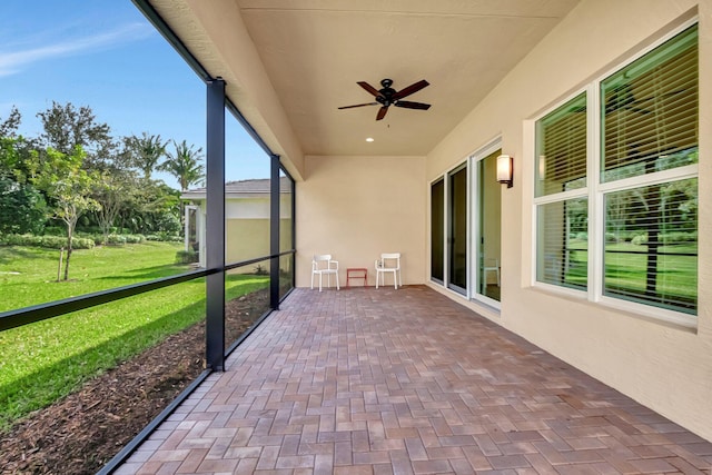 unfurnished sunroom with ceiling fan